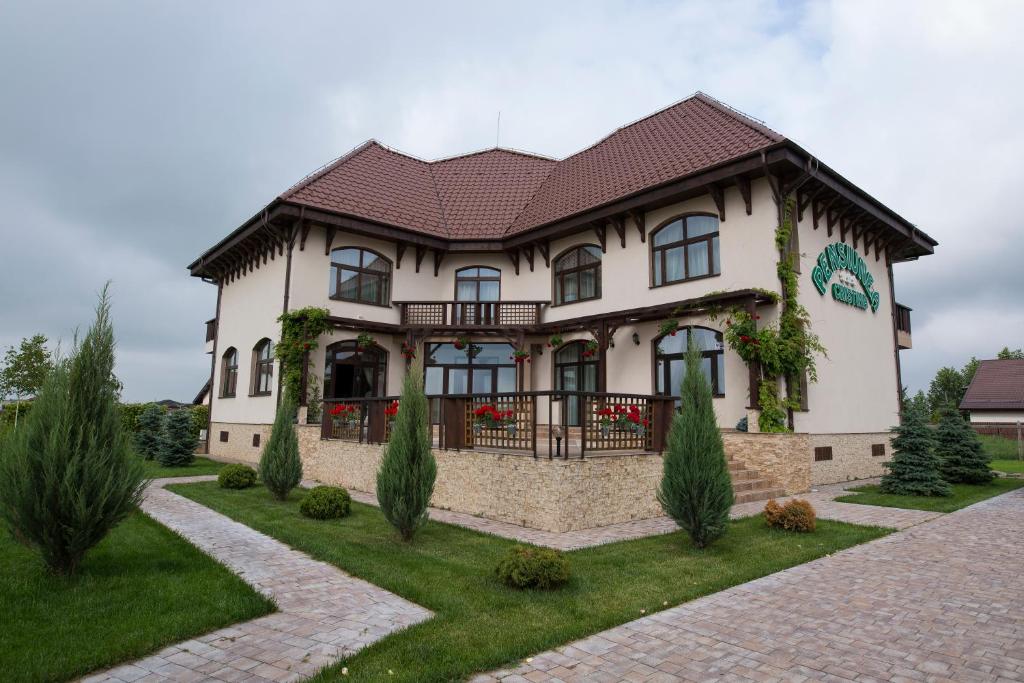 Casa blanca grande con techo marrón en Pensiunea Cristina, en Craiova