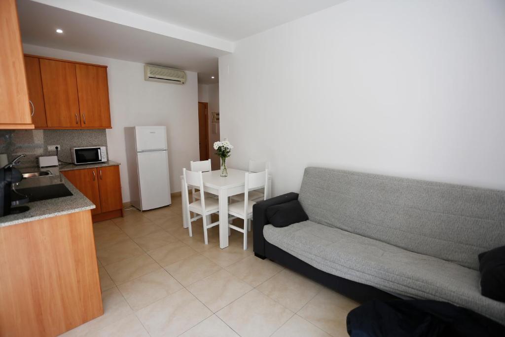 ein Wohnzimmer mit einem Sofa und eine Küche mit einem Tisch in der Unterkunft Apartaments Claudia in Reus