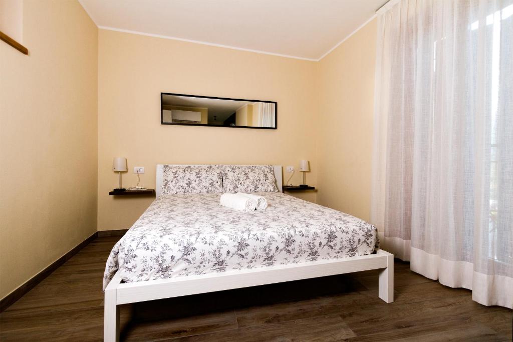 - une chambre avec un lit et un miroir dans l'établissement Andirivieni Bellagio Guest House, à Bellagio