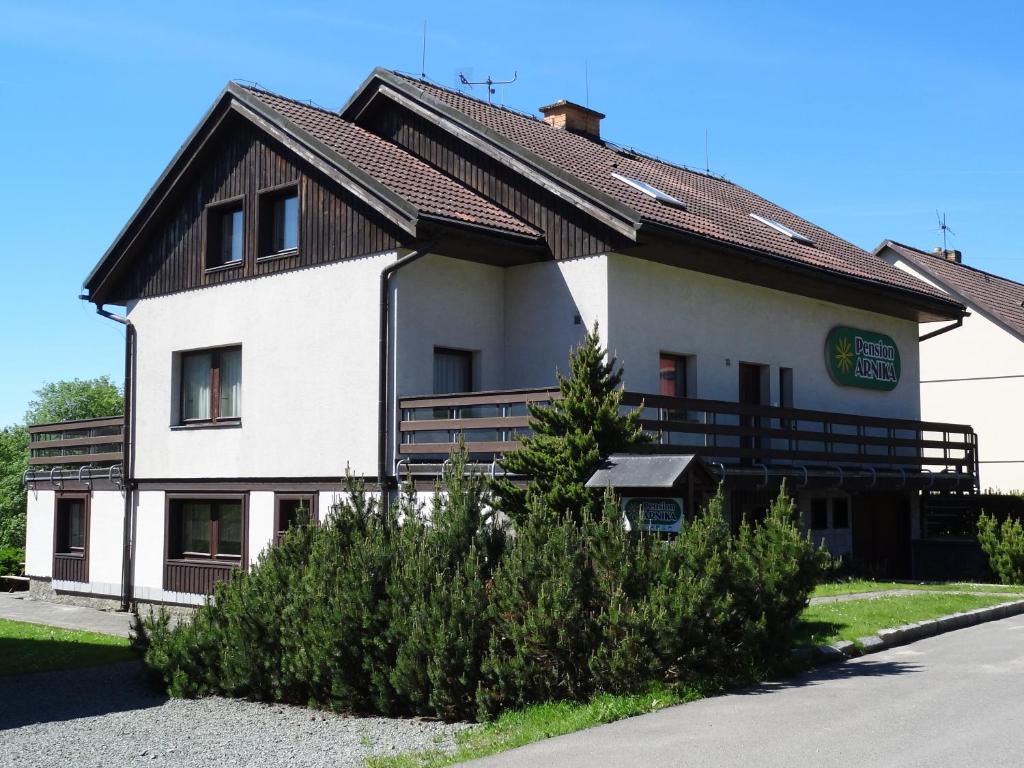 a large white building with a brown roof at Pension Arnika in Deštné v Orlických horách