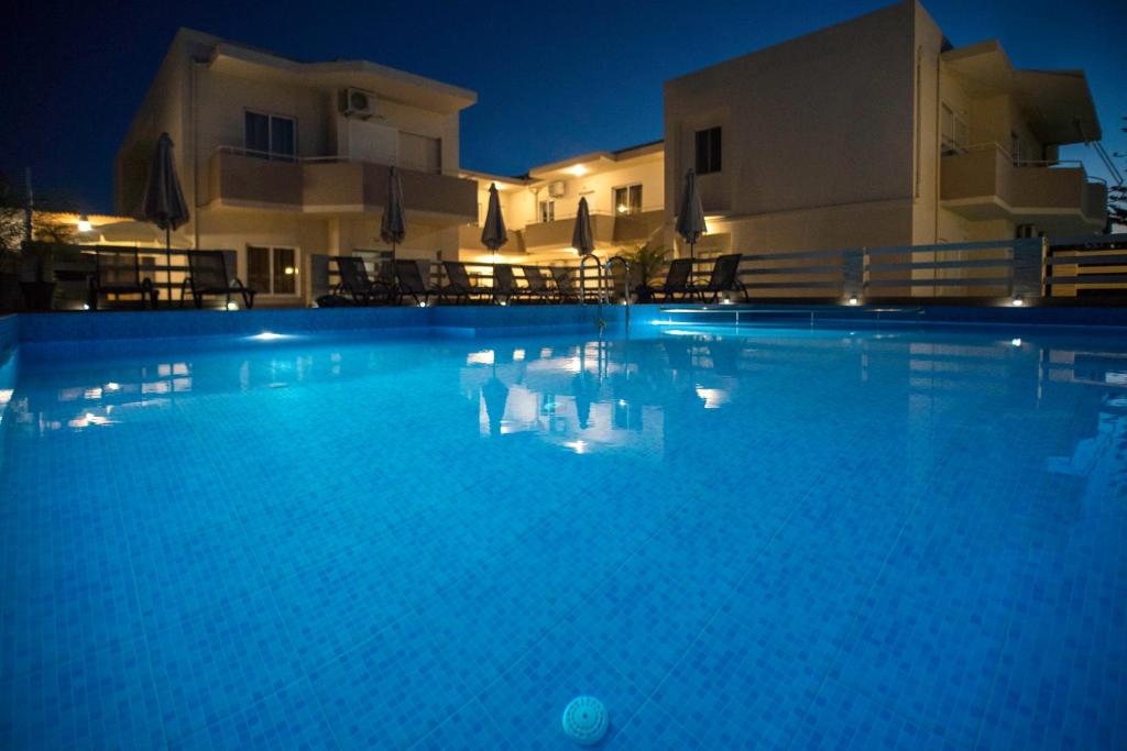 a large blue swimming pool at night at Naiades Luxury Apartments in Kalathas