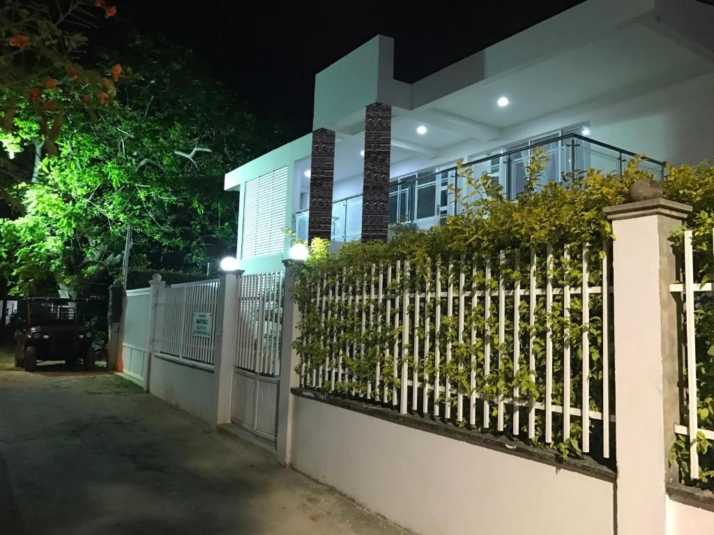 uma cerca em frente a uma casa à noite em Apartamentos Martinez em San Andrés