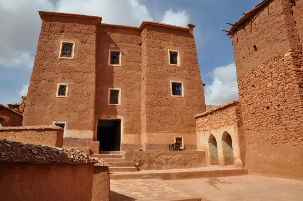 um velho edifício de tijolos com uma porta no meio em Kasbah Tigmi N'Oufella em Telouet