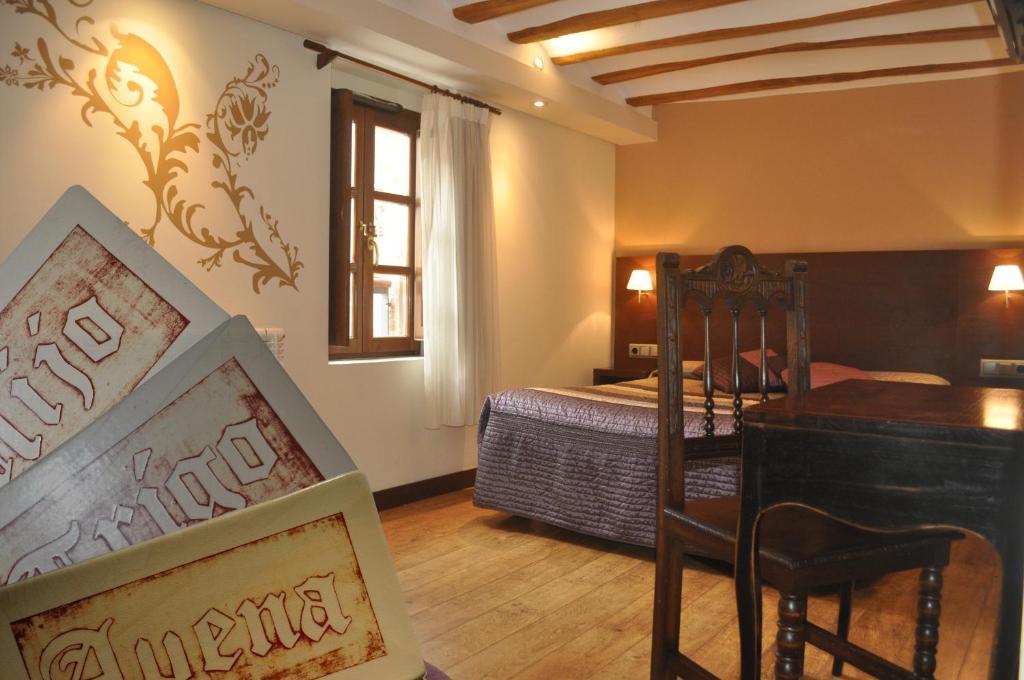 a bedroom with a bed and a table and chairs at El Molino de Floren in Santo Domingo de la Calzada