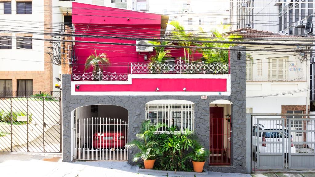un edificio con un edificio rosa con plantas. en Pousada e Hostel São Paulo Econômica en São Paulo