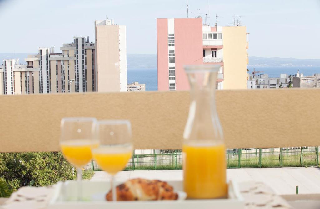 Dwa kieliszki soku pomarańczowego i chleb na stole w obiekcie Anna Blue Apartment w Splicie