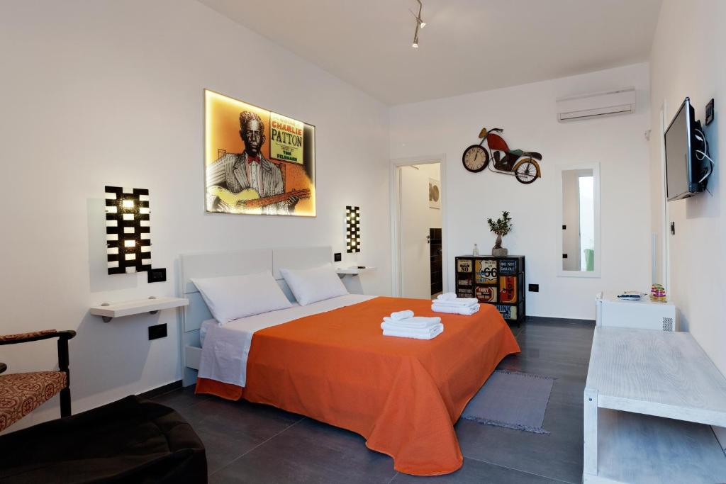 ein Schlafzimmer mit einem Bett mit einer orangefarbenen Decke in der Unterkunft Bed & Blues in Torre Lapillo