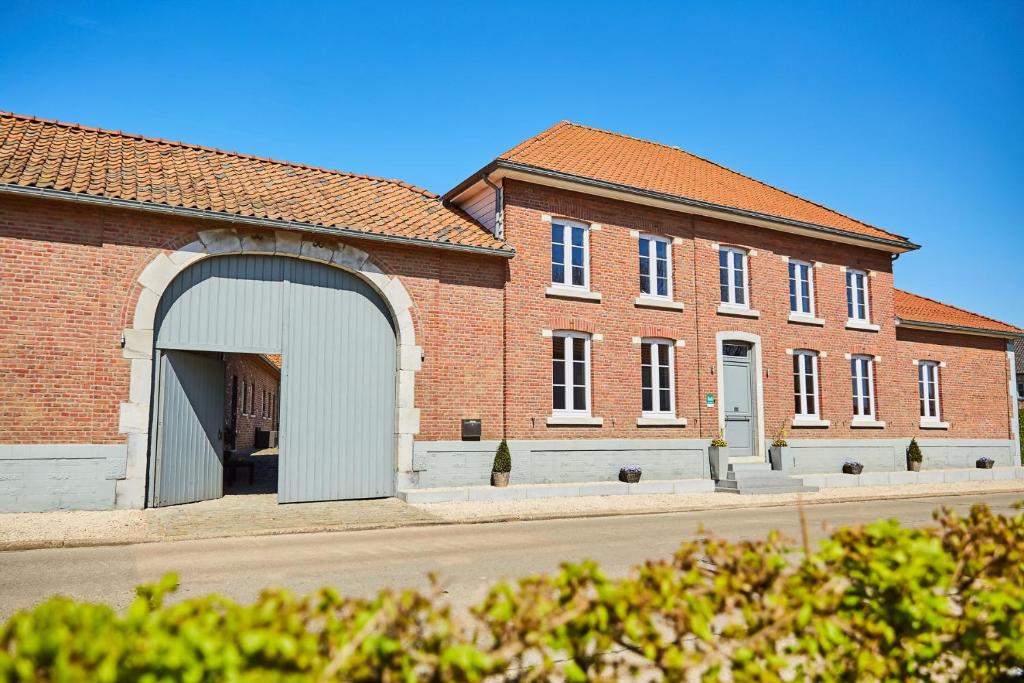 a large brick building with an open garage at Wellness B&B De Zevenslaper in Geetbets