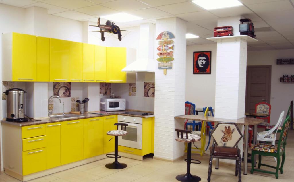 a kitchen with yellow cabinets and a table at City Hostel in Sochi