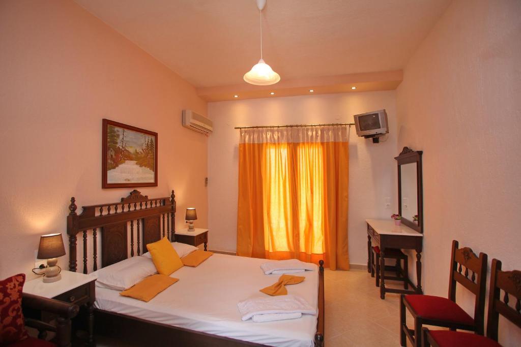 a bedroom with a bed and a desk and a window at Maria Studios in Neo Klima