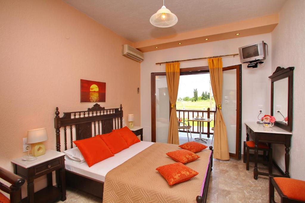 a bedroom with a bed with orange pillows and a desk at Maria Studios in Neo Klima