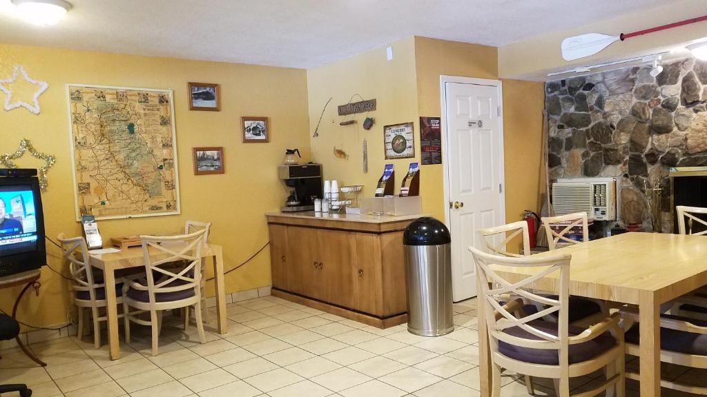 a restaurant with a bar and a table and a tv at Golden Chain Motel in Grass Valley