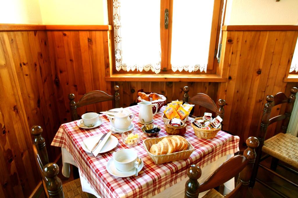 una mesa con pan y tazas y cestas de comida en Hotel Edelweiss en Villeneuve