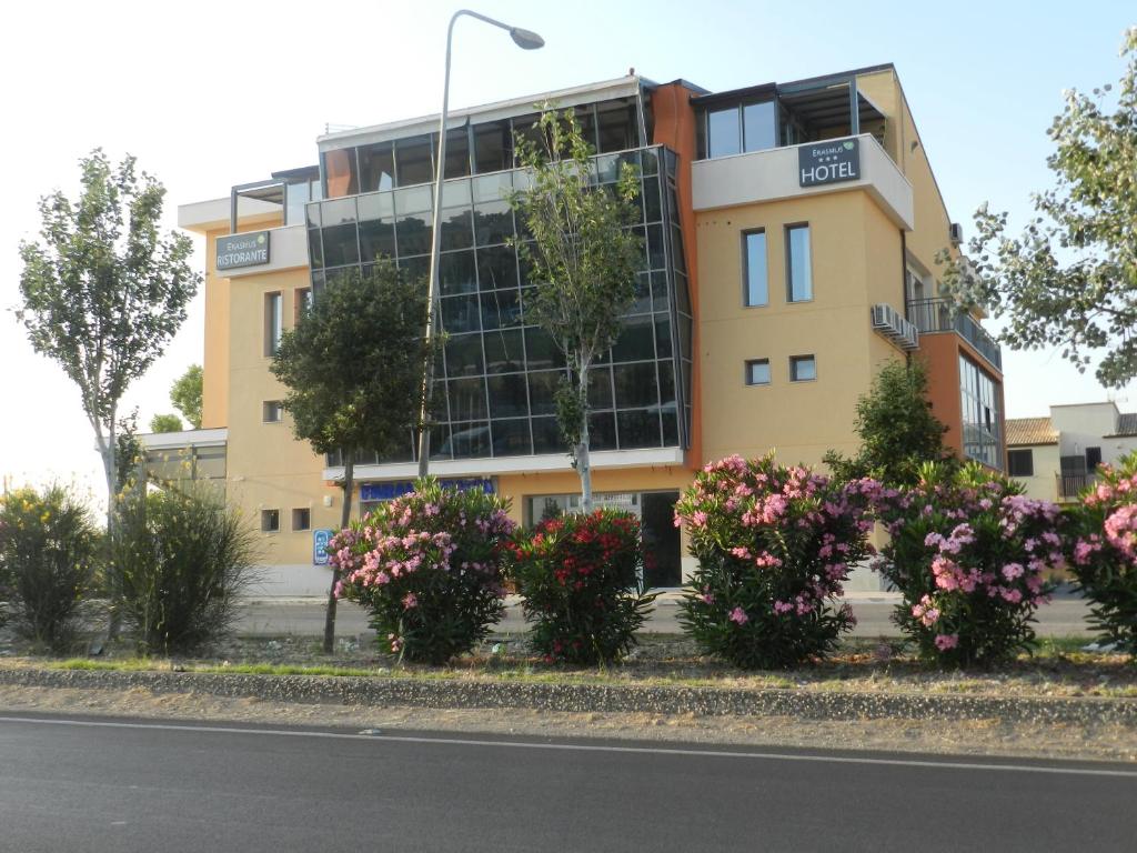 a yellow building with flowers in front of it at Erasmus Hotel in Gela