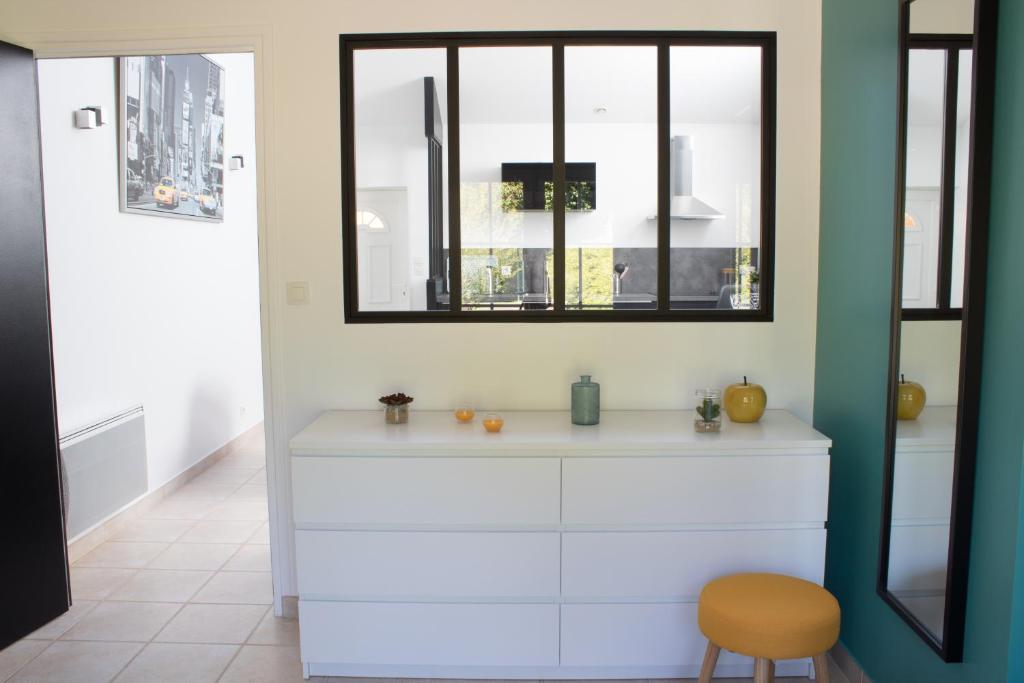 Cette chambre comprend une commode blanche et une fenêtre. dans l'établissement Le loft du Clos d'Esquay, à Esquay-sur-Seulles