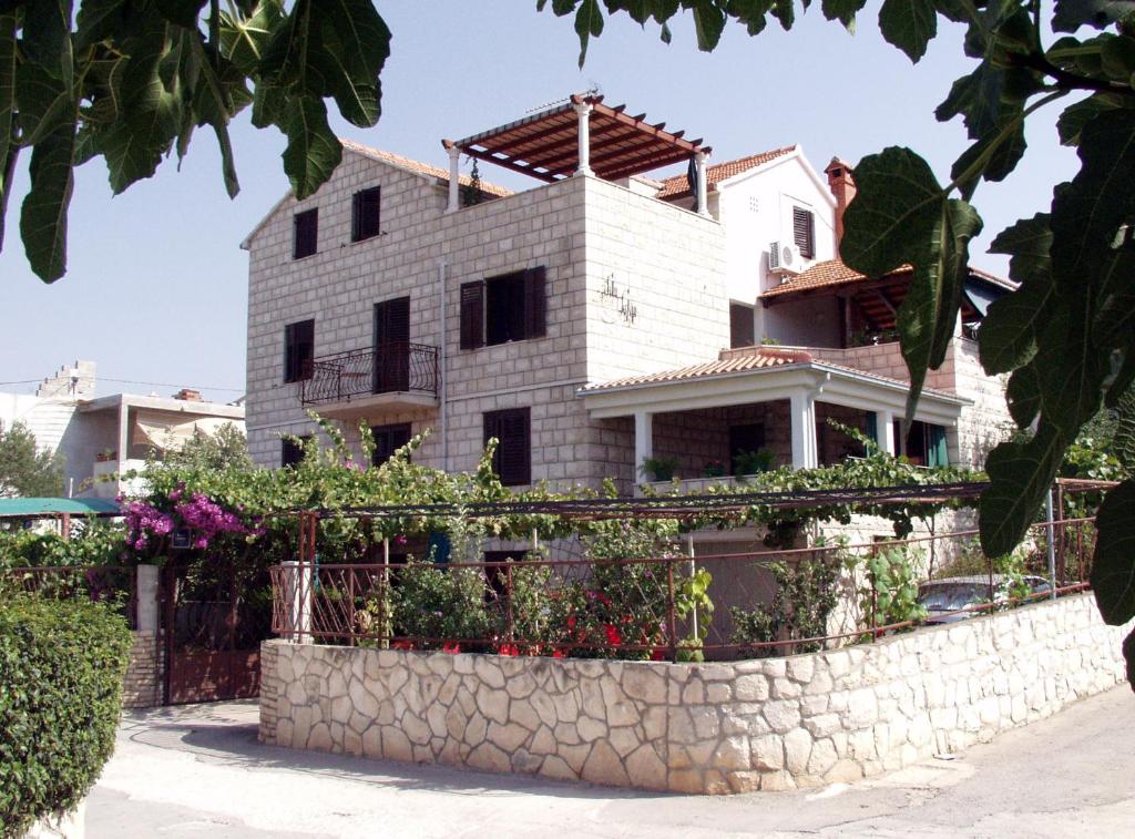 a house with a stone fence in front of it at Villa Sofija in Supetar