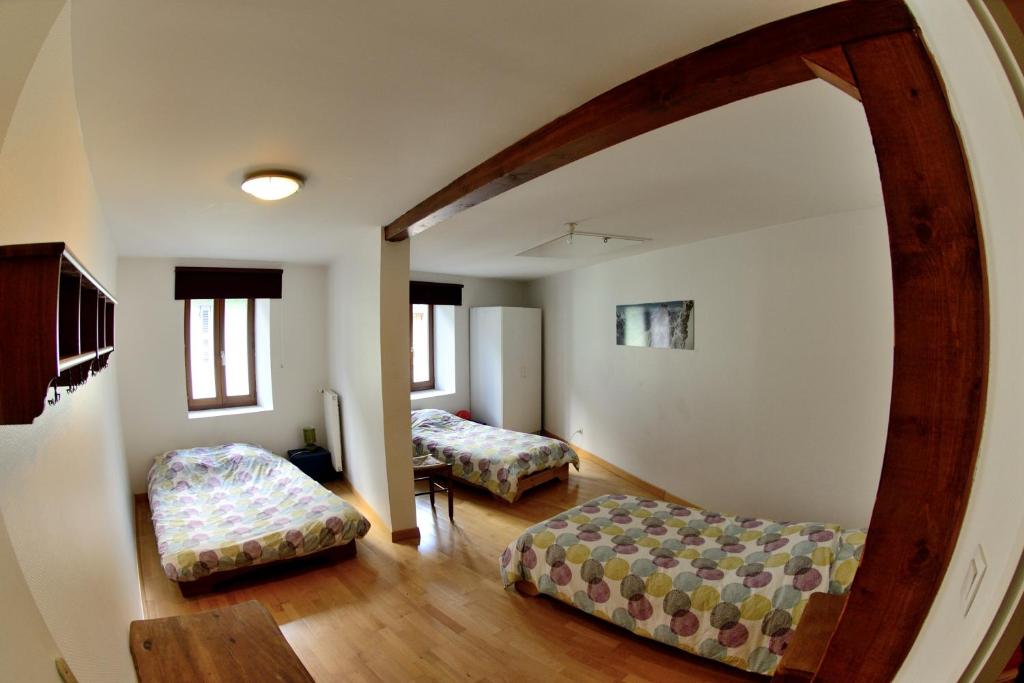Sala de estar con 2 camas y espejo en Refuge du Vieux Bourg en Le Châtelard