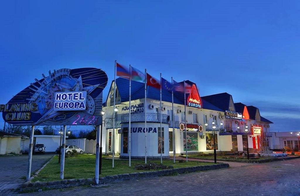 een hotelgebouw met borden ervoor bij Europa Hotel-Kutaisi in Koetaisi