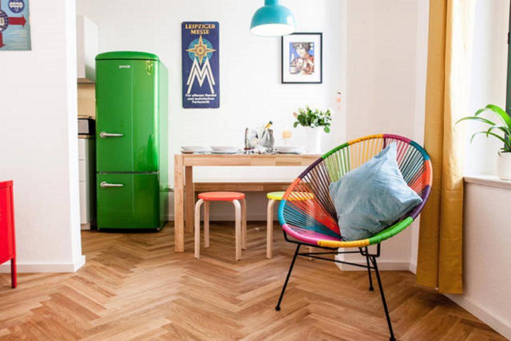 uma cozinha com um frigorífico verde e uma cadeira em Enjoy Leipzig em Leipzig