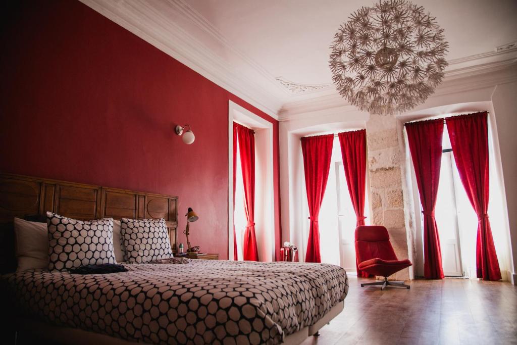Schlafzimmer mit roten Wänden und einem Bett mit Kronleuchter in der Unterkunft Asul B&B in Lissabon