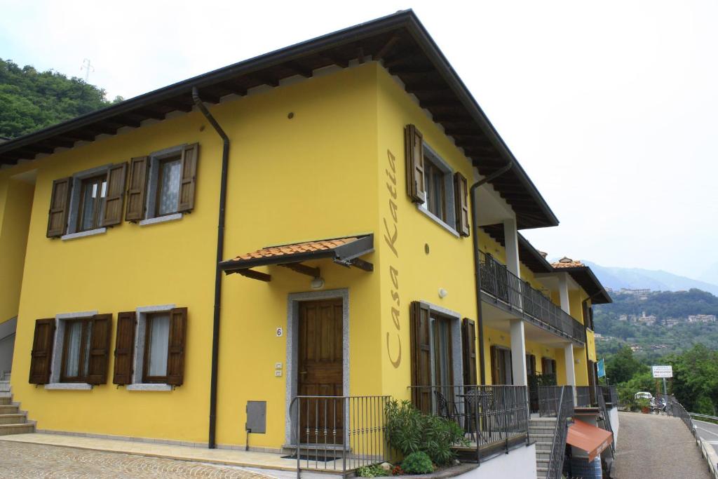 una casa amarilla con techo negro en Appartamenti Katia, en Tremosine Sul Garda