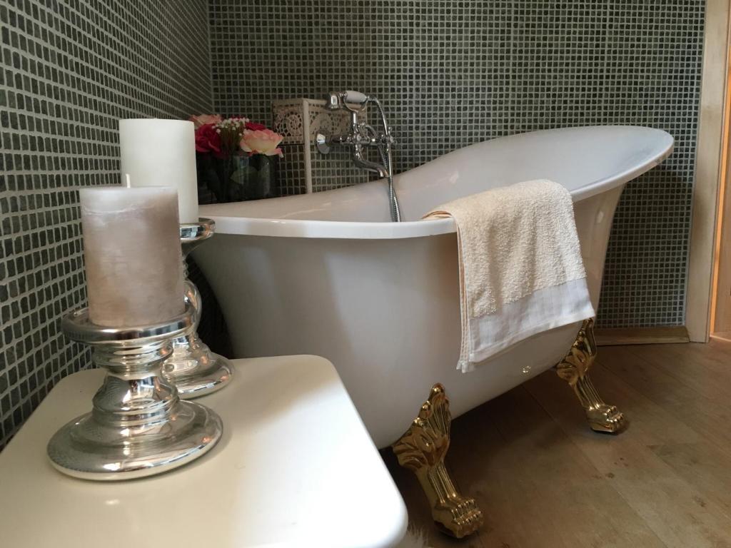 a bathroom with a bath tub and a candle on a toilet at Villa di Piazza in Višnjan
