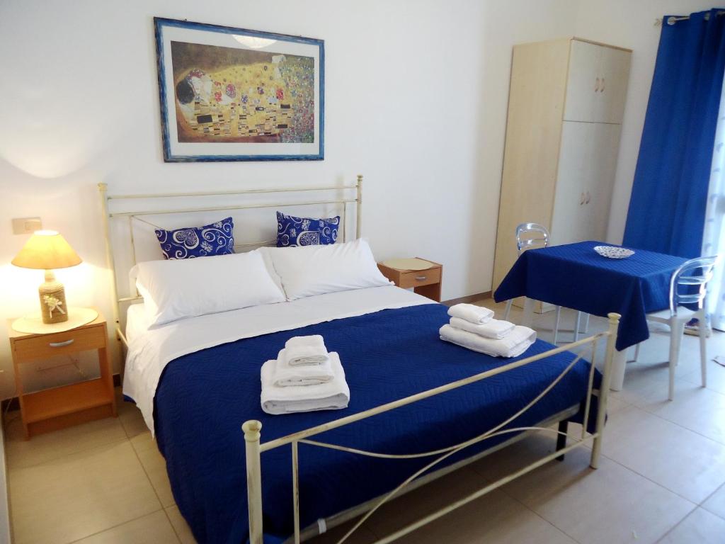 パチェーコにあるApartments Drago di Ferroのベッドルーム1室(青い毛布、テーブル付)