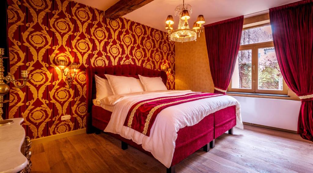 a bedroom with a bed with a red wall at Maison Au Cheval Noir in Maastricht