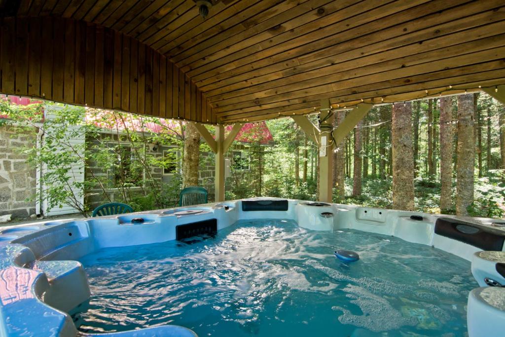 una bañera de hidromasaje en el patio trasero de una casa en Camping Chalets Spas Pignons Rouges, en Saint Romain