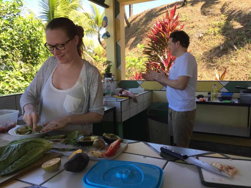 un hombre y una mujer preparando comida en una cocina en La Terraza Verde, en Drake