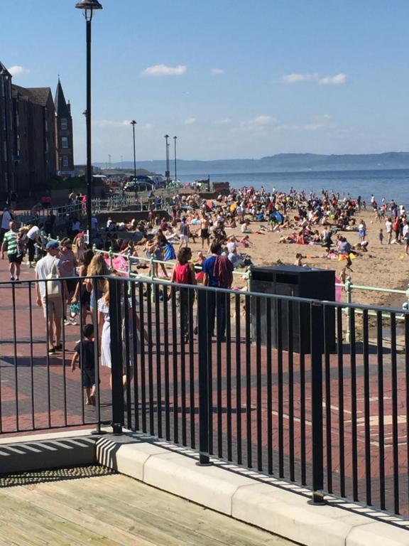 a crowd of people on the beach near a fence at Apartment on the beach in Edinburgh