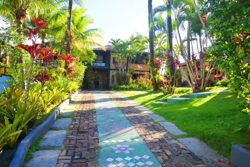 a walkway in front of a resort with palm trees at Pousada Mar Aberto in Arraial d'Ajuda