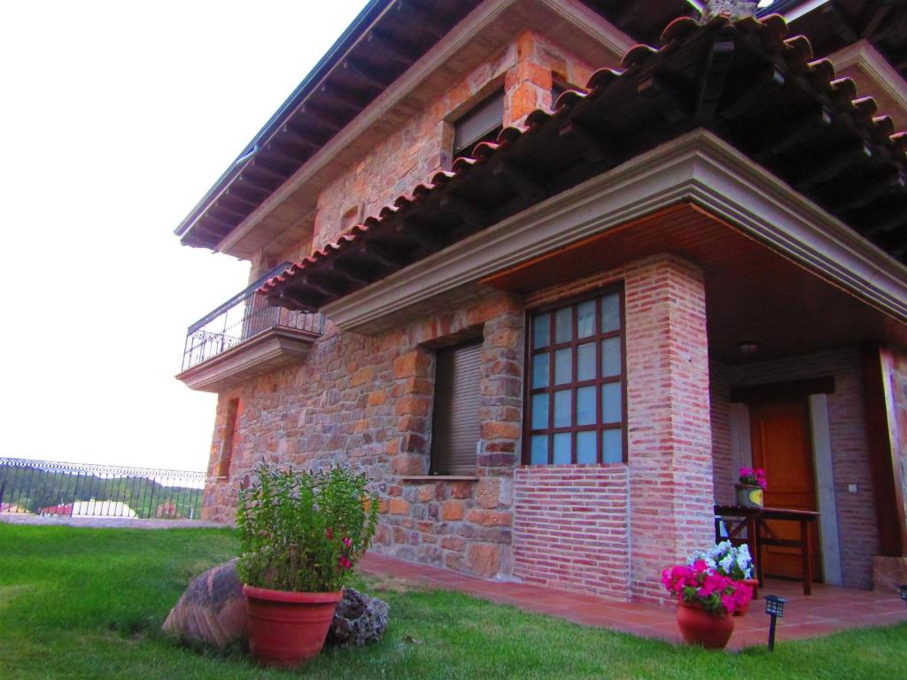 uma casa de tijolos com dois vasos de plantas em frente em Casa en ambiente tranquilo y relajante em Garray