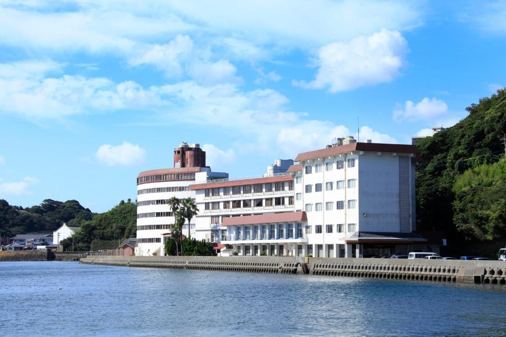 un grande edificio bianco accanto a un corpo d'acqua di Hirado Kaijyo Hotel a Hirado