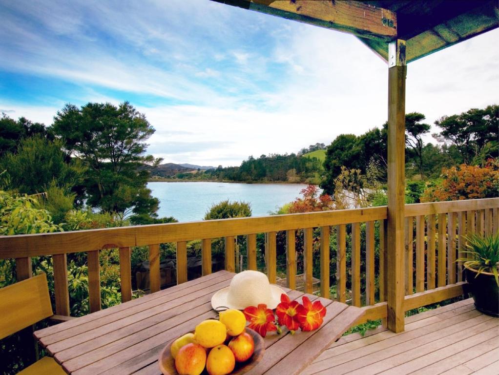 a bowl of fruit sitting on a table on a deck at Bay of Islands Cottages in Russell
