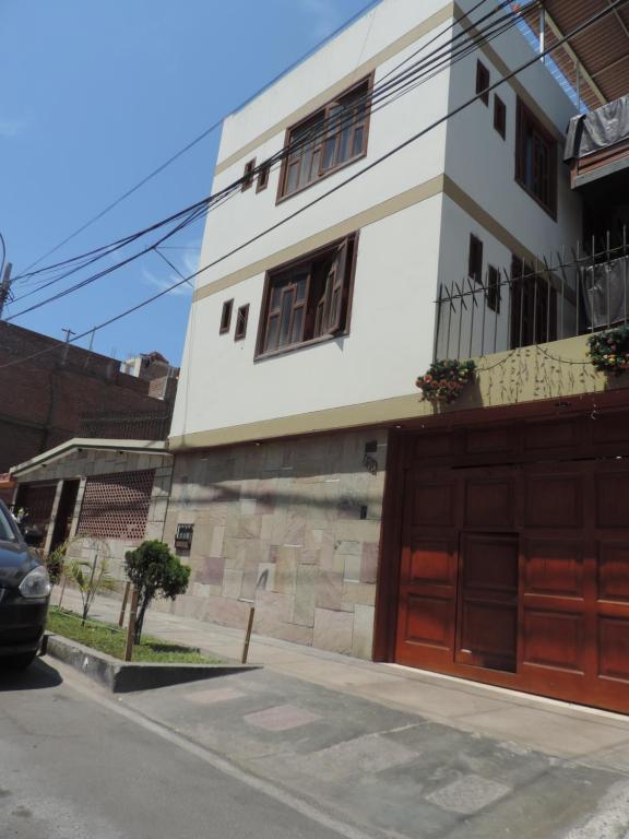a white house with brown doors on a street at Departamento Para Turistas in Lima