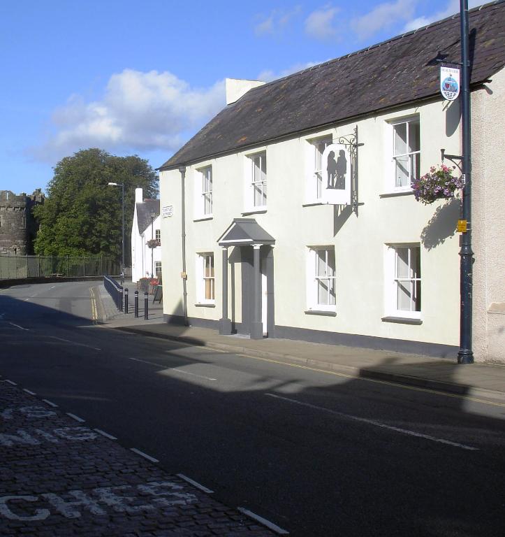 a white building on the side of a street at Castle Square Apartments Beaumaris in Beaumaris