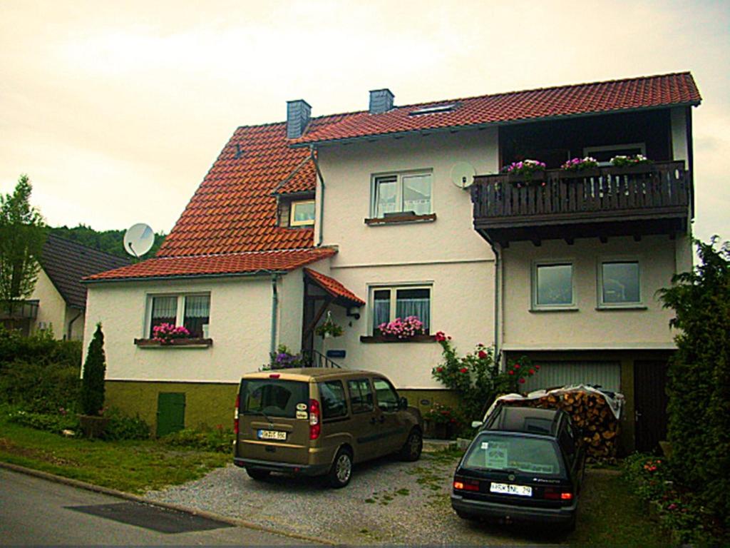 zwei Autos, die vor einem Haus geparkt sind in der Unterkunft Apartment Am Hemberg in Bontkirchen