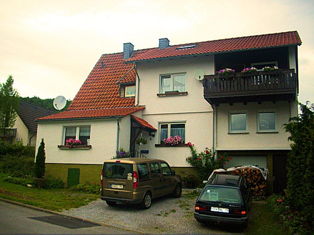 dos autos estacionados frente a una casa en Apartment Am Hemberg, en Bontkirchen