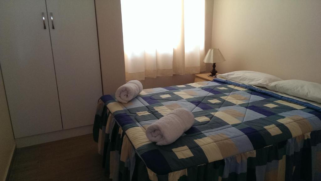 1 dormitorio con 1 cama con toallas en Huaraz Apartamentos, en Huaraz