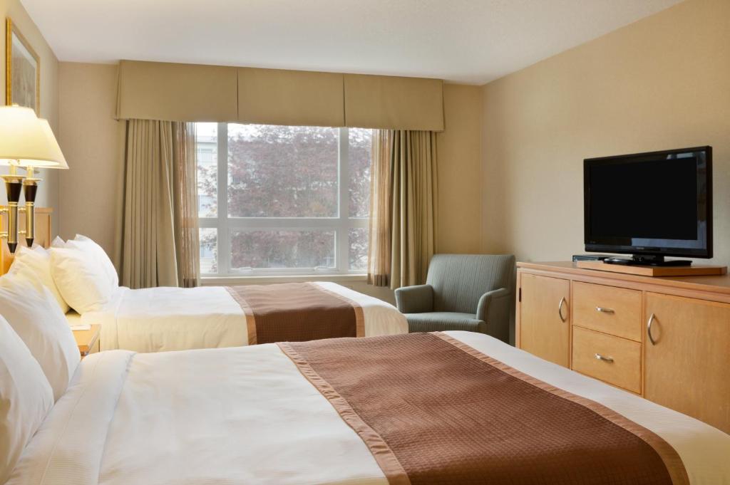 Postel nebo postele na pokoji v ubytování Ramada by Wyndham Nanaimo