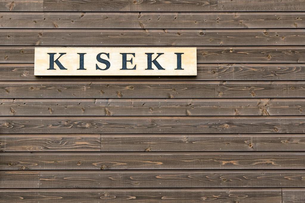 Ein Schild, auf dem "Küssen an einer Holzwand" steht. in der Unterkunft Kiseki in Niseko