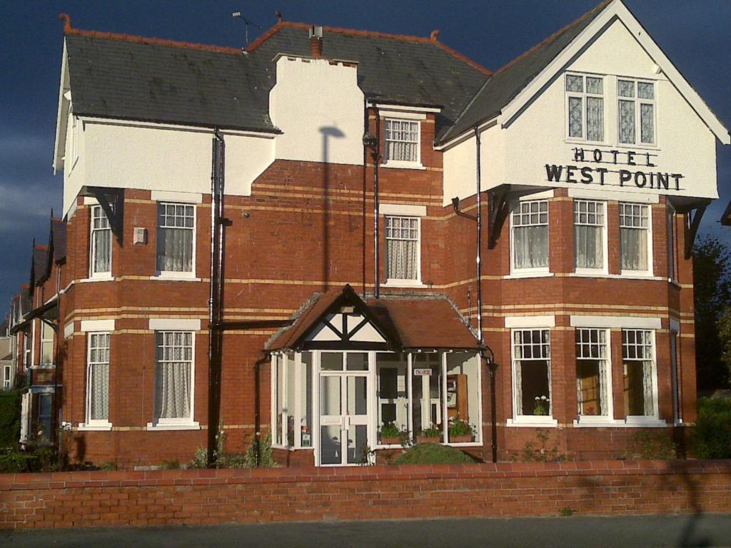 un edificio de ladrillo con una señal de punto oeste en él en West Point Hotel Bed and Breakfast, en Colwyn Bay