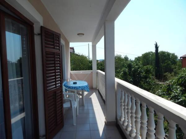 a balcony with a blue table and chairs on it at Apartments Vilanija in Vilanija