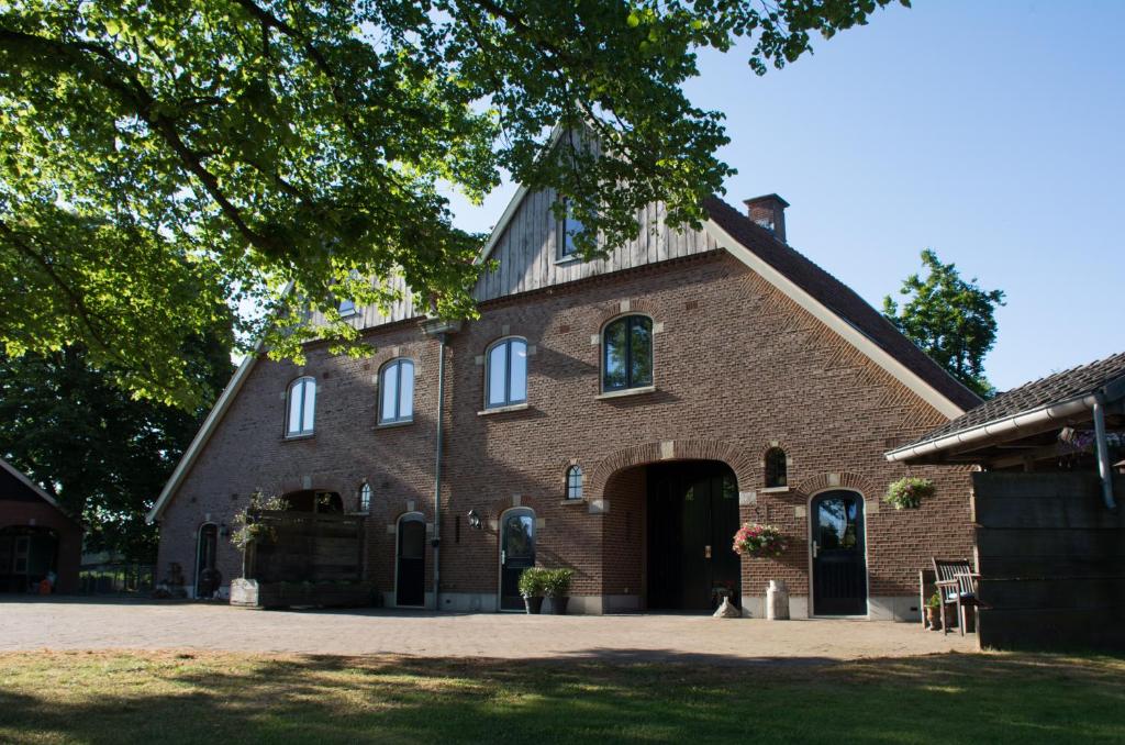 een groot gebouw van rode baksteen met een grote deuropening bij Erve de Bosch in Benteloo