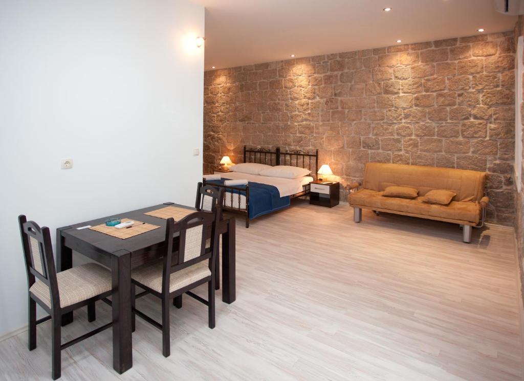 a room with a bed and a table and chairs at Apartments Galić in Split