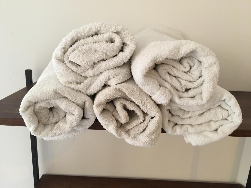 stos białych ręczników na półce w obiekcie Jolie Maison w mieście Santa Margherita Ligure