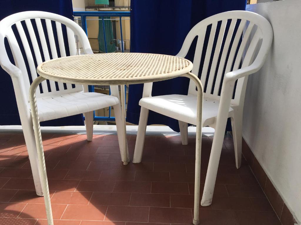 dwa białe krzesła oraz stół i krzesła w obiekcie Jolie Maison w mieście Santa Margherita Ligure