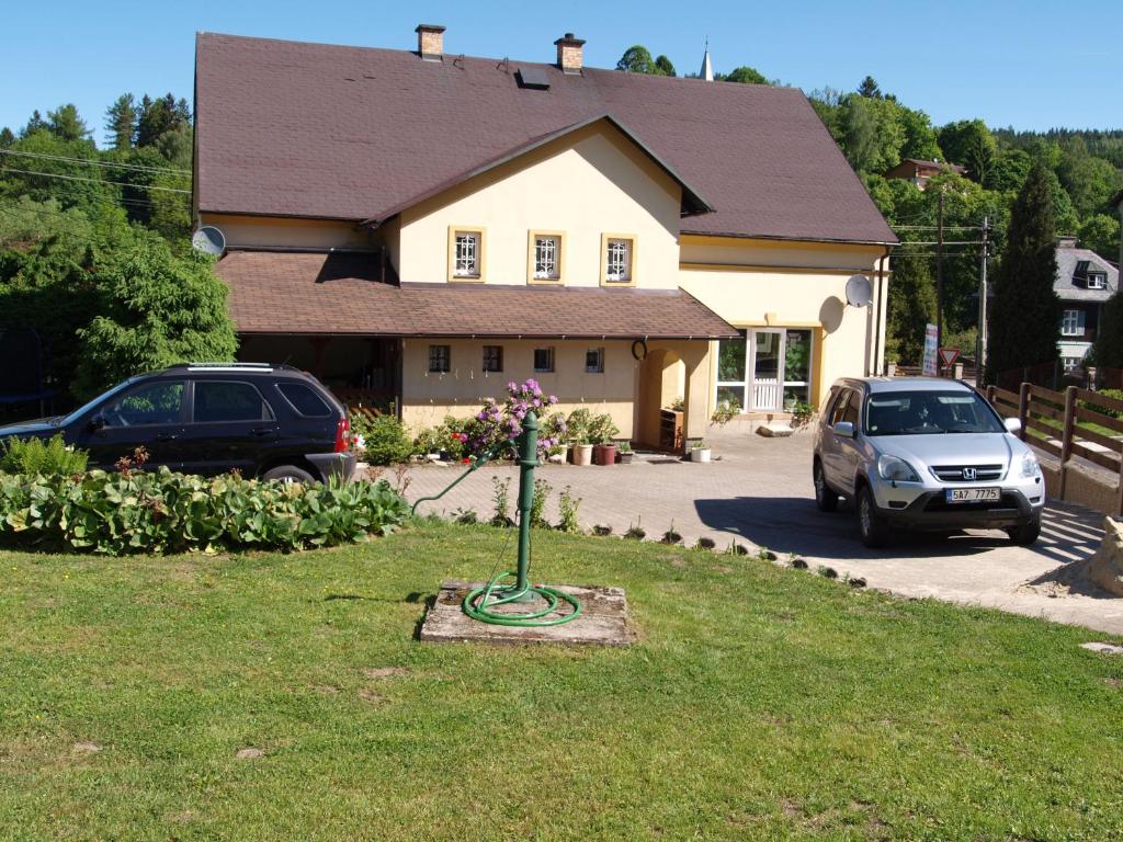 a house with a car parked in a yard at Penzion Kuba in Smržovka