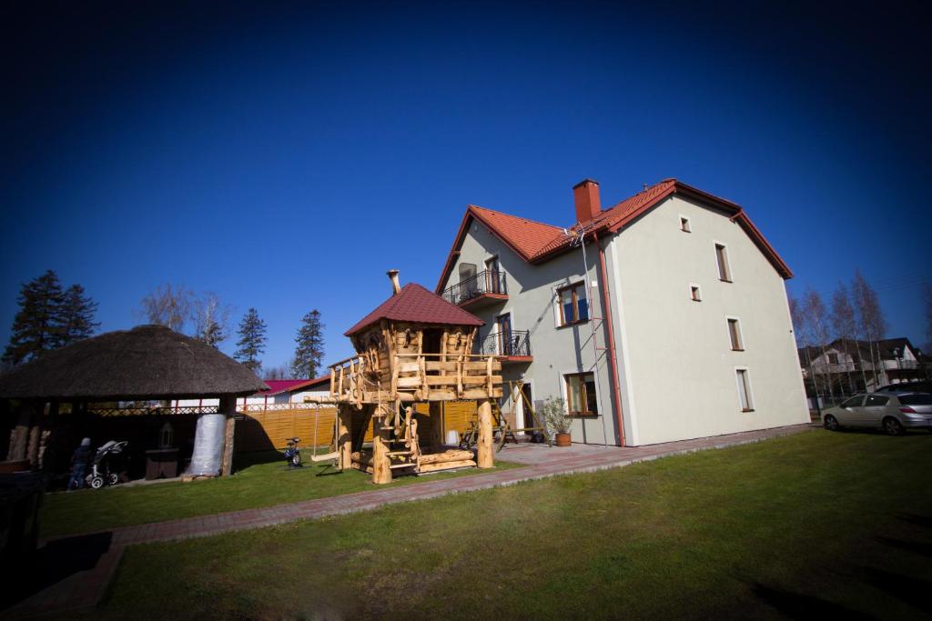 una grande casa bianca con una casa sull'albero di Villa Remedios a Łeba